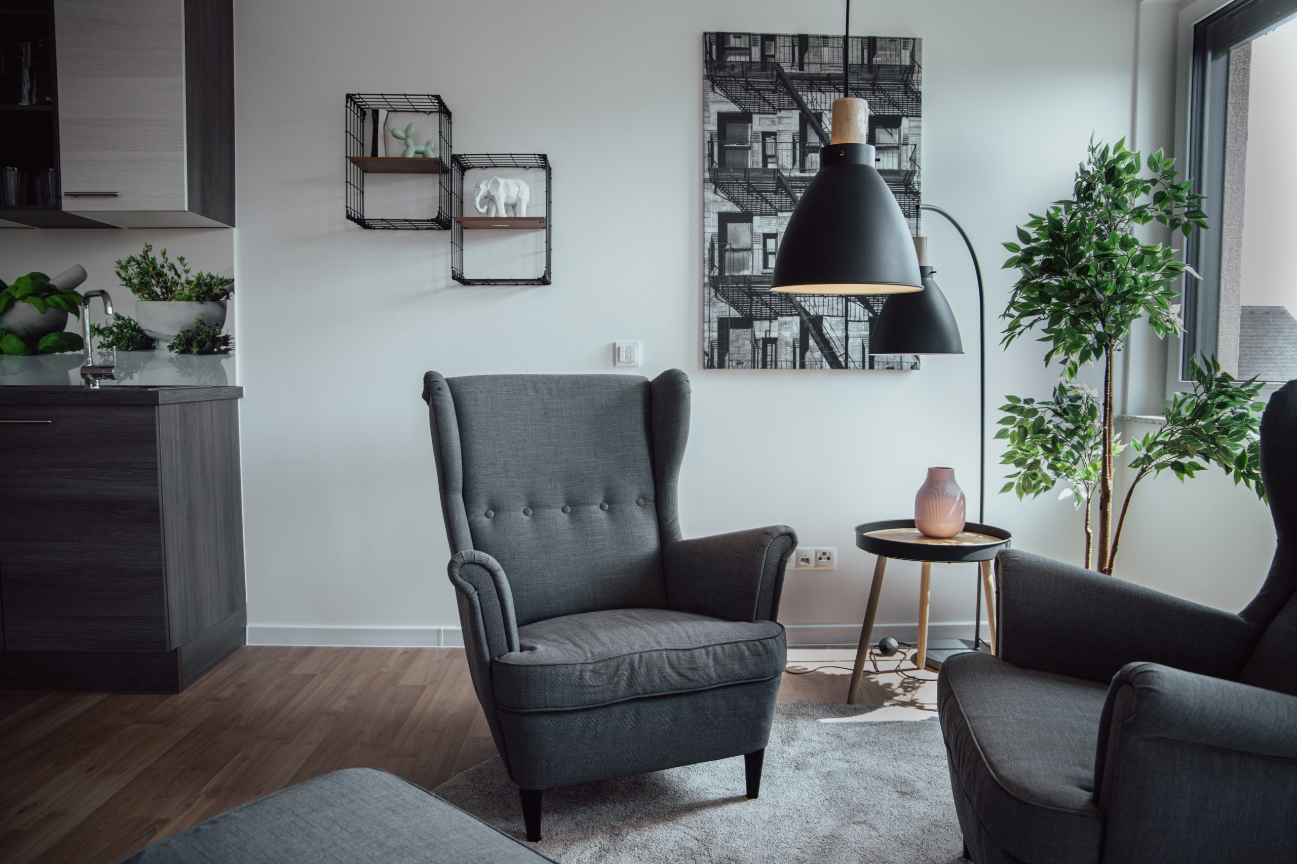Wohnzimmer mit grauen Sesseln und KNX-gesteuerter Beleuchtung für mehr Komfort durch Siblik Smart Home